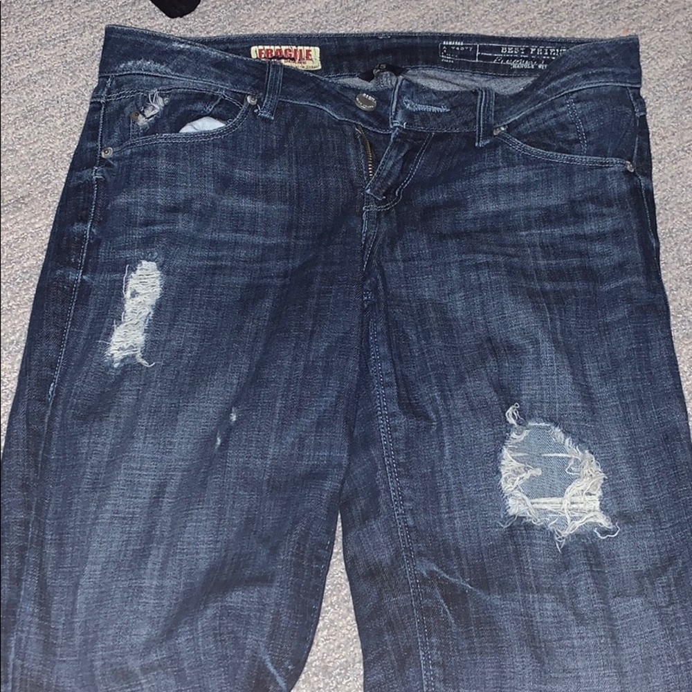 Ripped blue jeans. Straight cut.